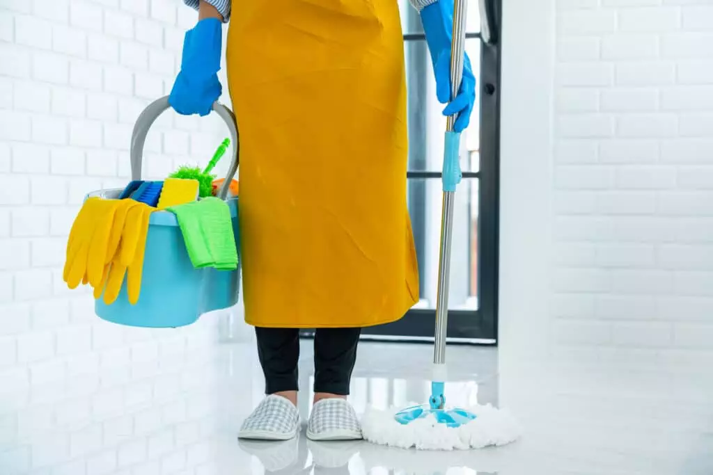 house cleaner holding mop and a bucket full of cleaning supplies doing deep cleaning services in Plano, TX